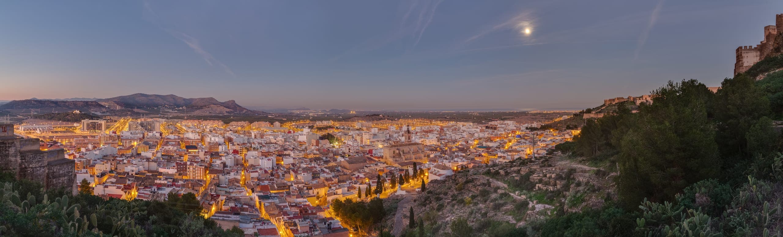 Vista panorámica de Sagunto al atardecer, con el castillo sobre la colina